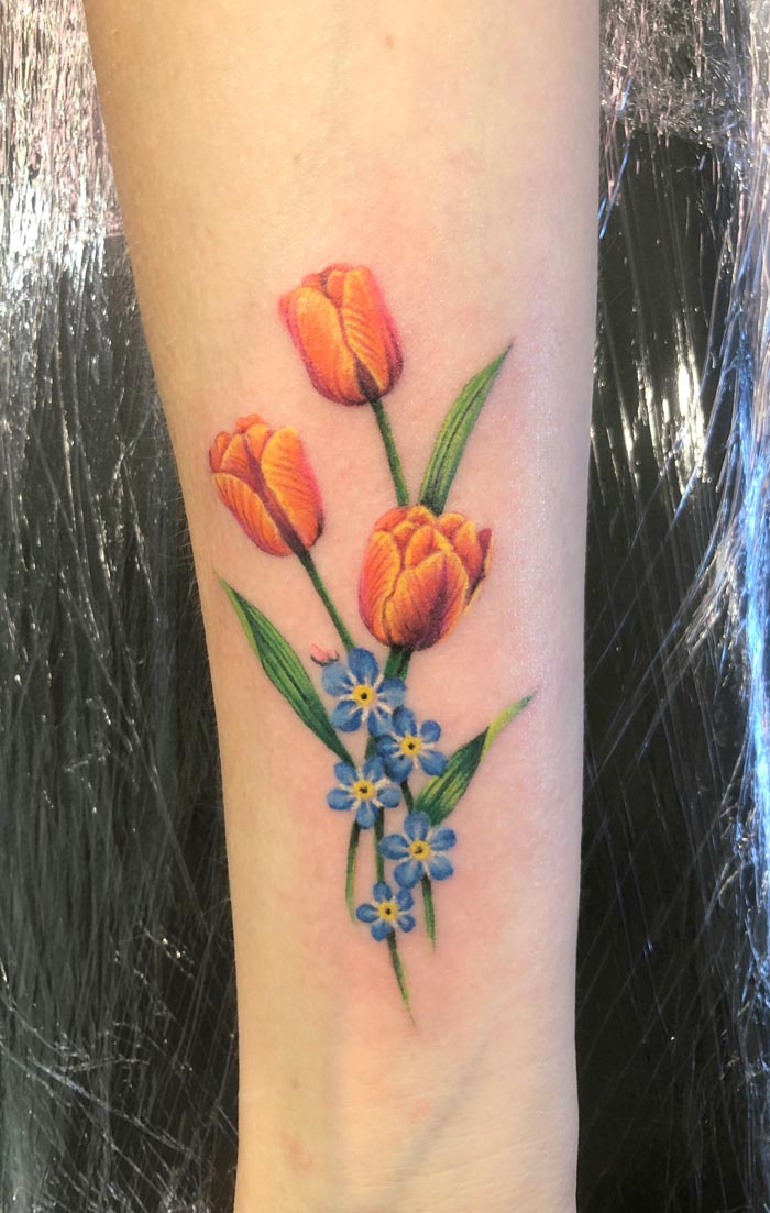 Tulips and forget-me-nots on the forearm
