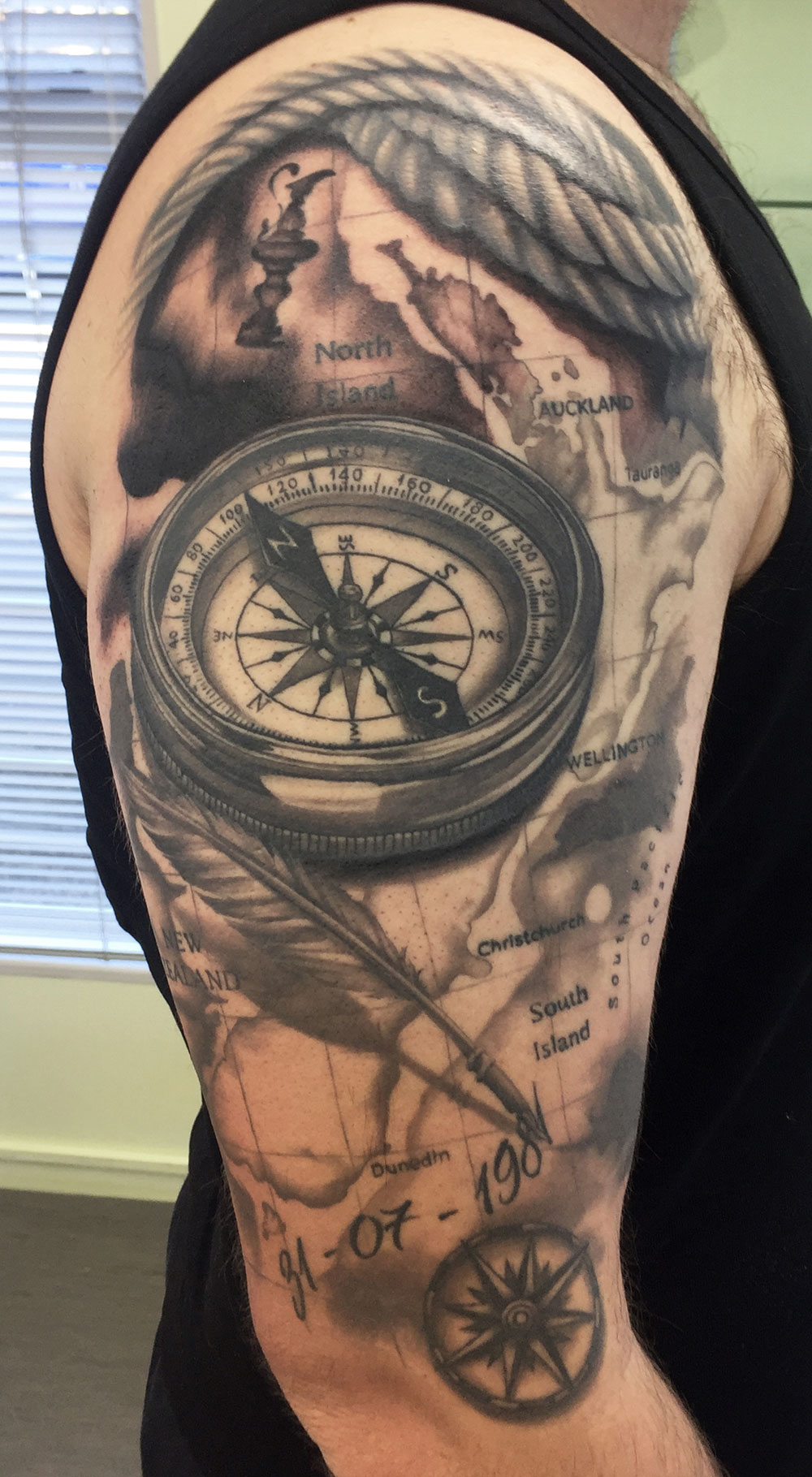 Compass and map sleeve tattoo - black and grey travel-themed realism