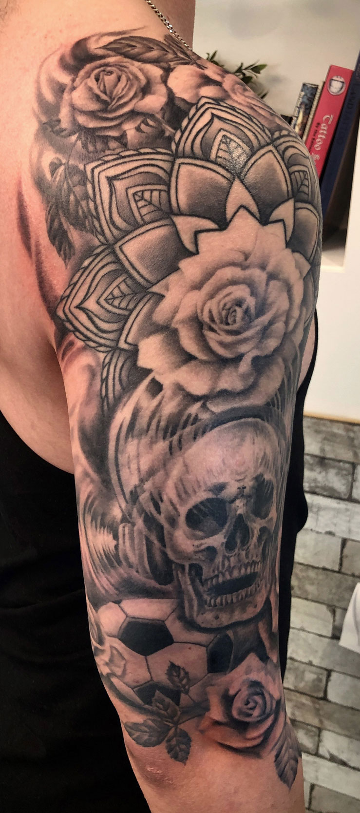 Black and grey tattoo sleeve with skull and rose design - realism detail