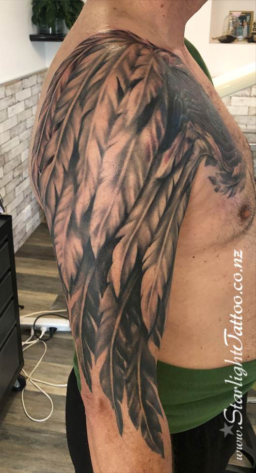 Feather tattoo down arm - soft black and grey realism