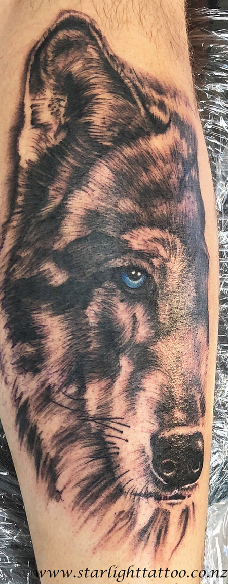 Half wolf in black and grey ink with a blue eye