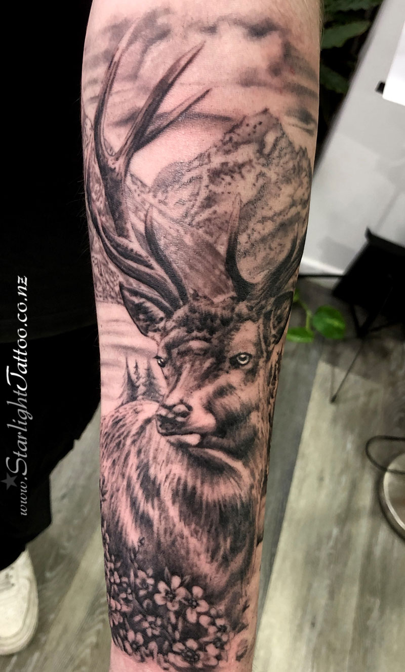 Stag with Mt Cook and tea tree - New Zealand realism tattoo