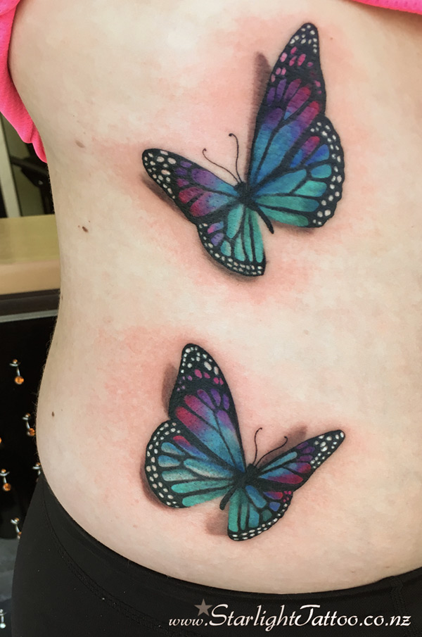 Butterflies in flight tattooed across the ribs