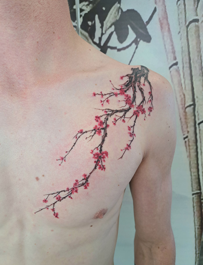 Cherry blossoms in soft pink hues - gentle colour tattoo crafted in Auckland