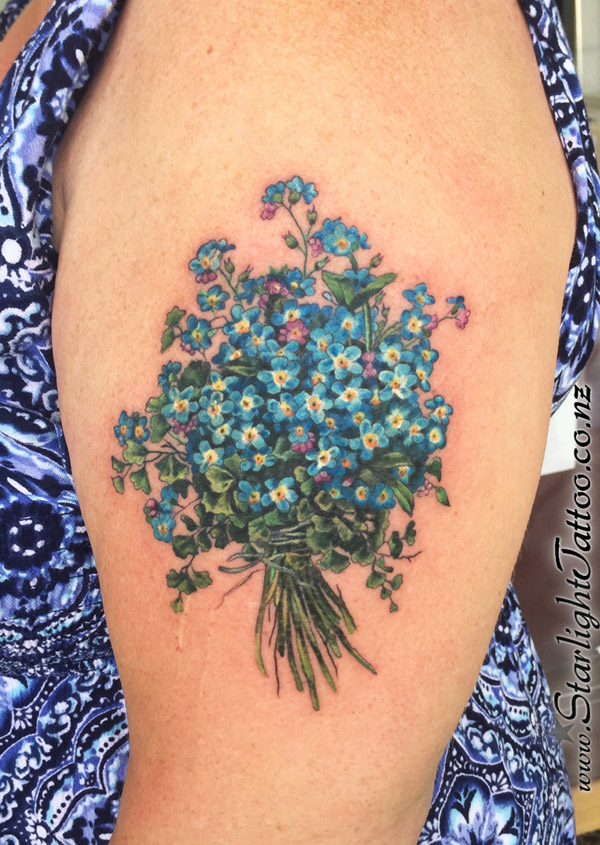 Forget-me-nots in calming blue - a symbolic fine line colour tattoo from Auckland