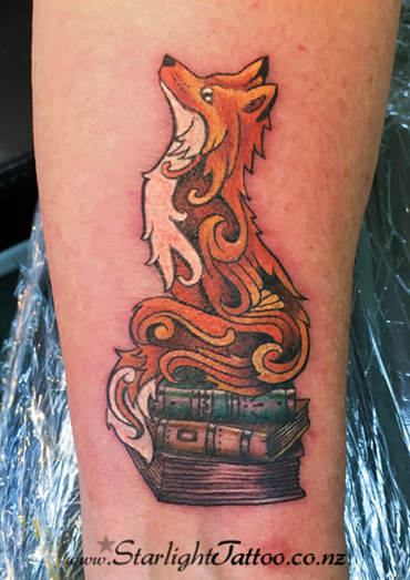 A colourful tattoo featuring fox sitting on books - tattoo art in New Zealand