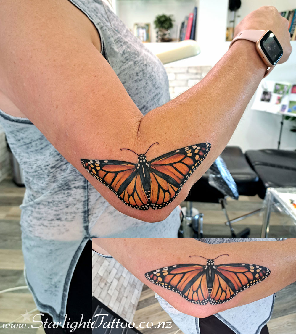 Monarch butterfly captured in flight - crisp and detailed colour tattoo from Auckland