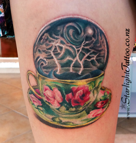 Storm-in-a-teacup concept tattoo with sky and waves - creative tattoo Auckland
