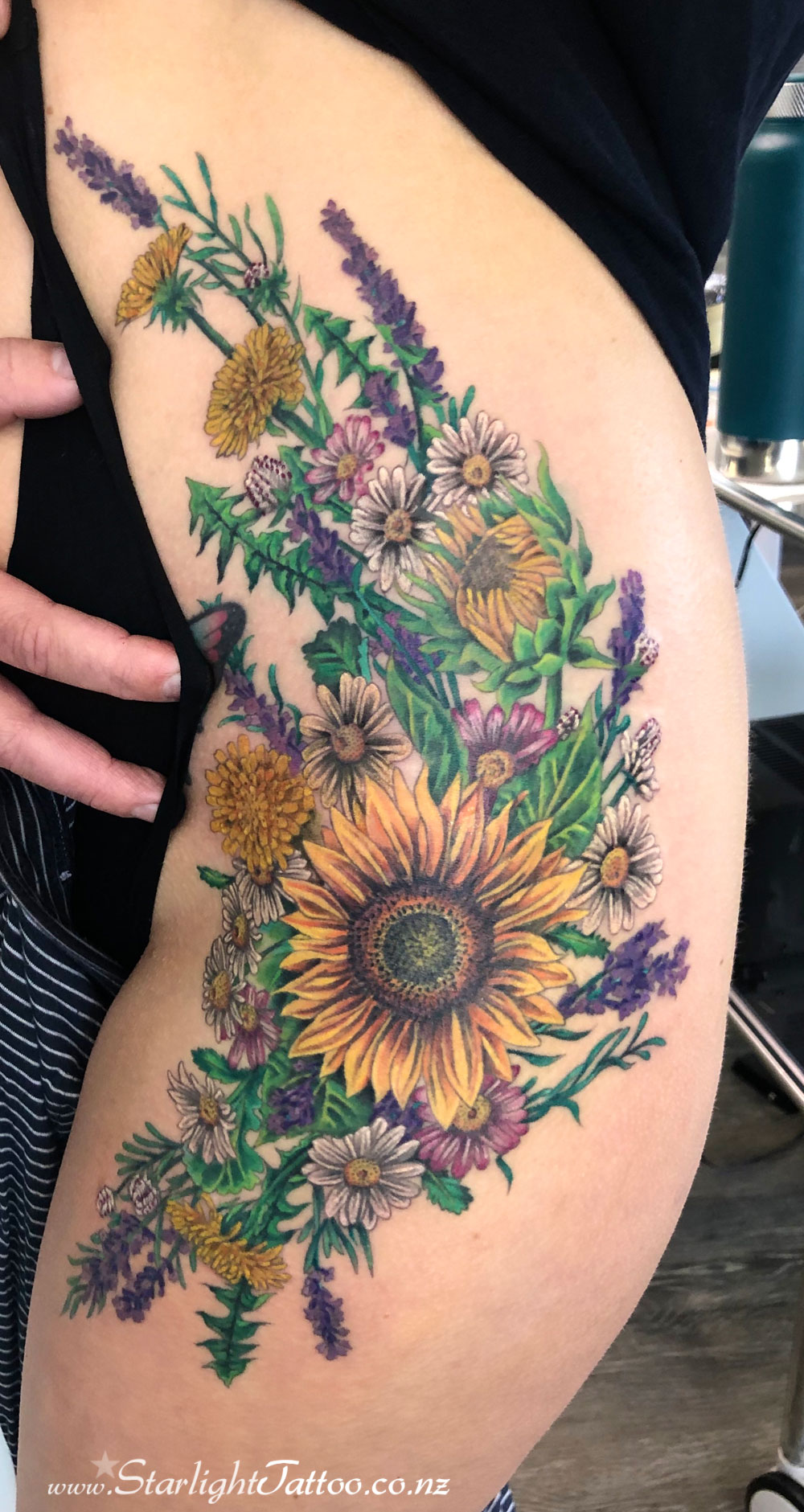 Thigh tattoo with blooming florals - soft feminine piece with flowing movement