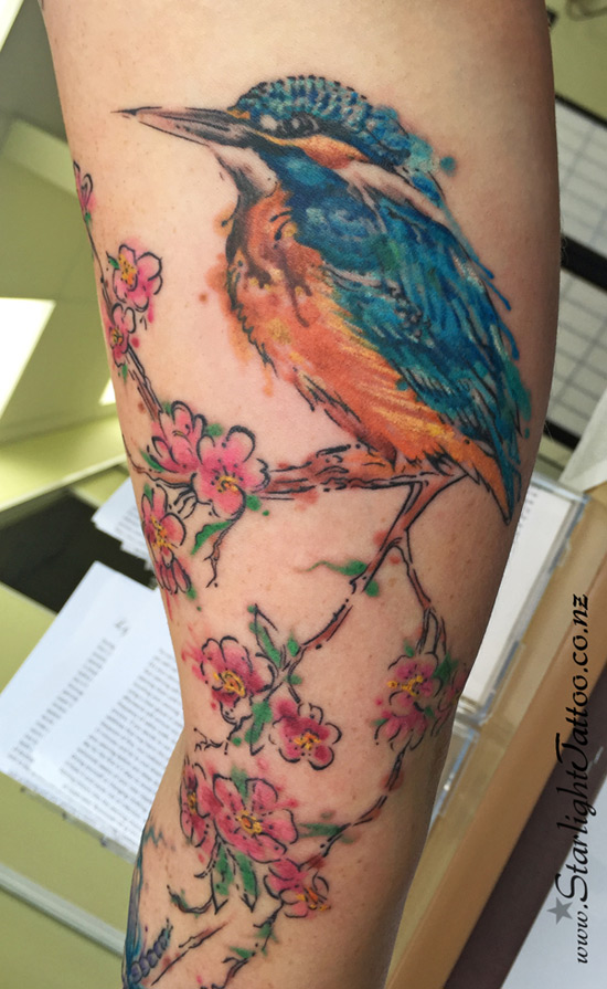 A vibrant depiction of watercolor kingfisher cherry blossoms - watercolour tattoos Auckland