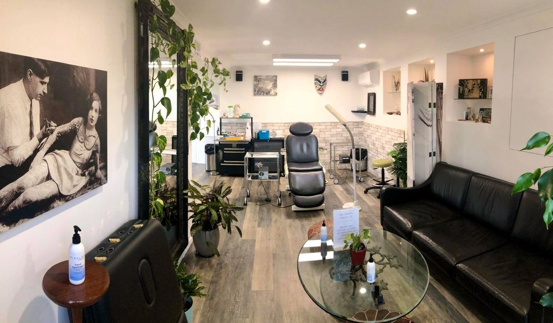 Modern tattoo workspace with plants and artwork on the walls